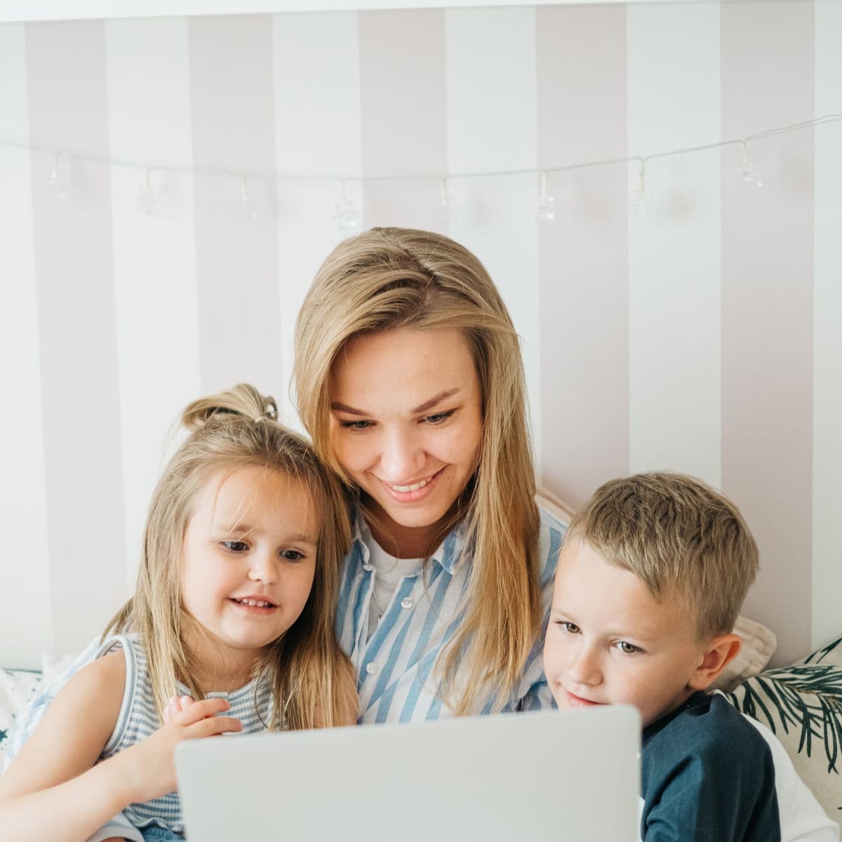 A family smiling while watching a wedding livestream together from home